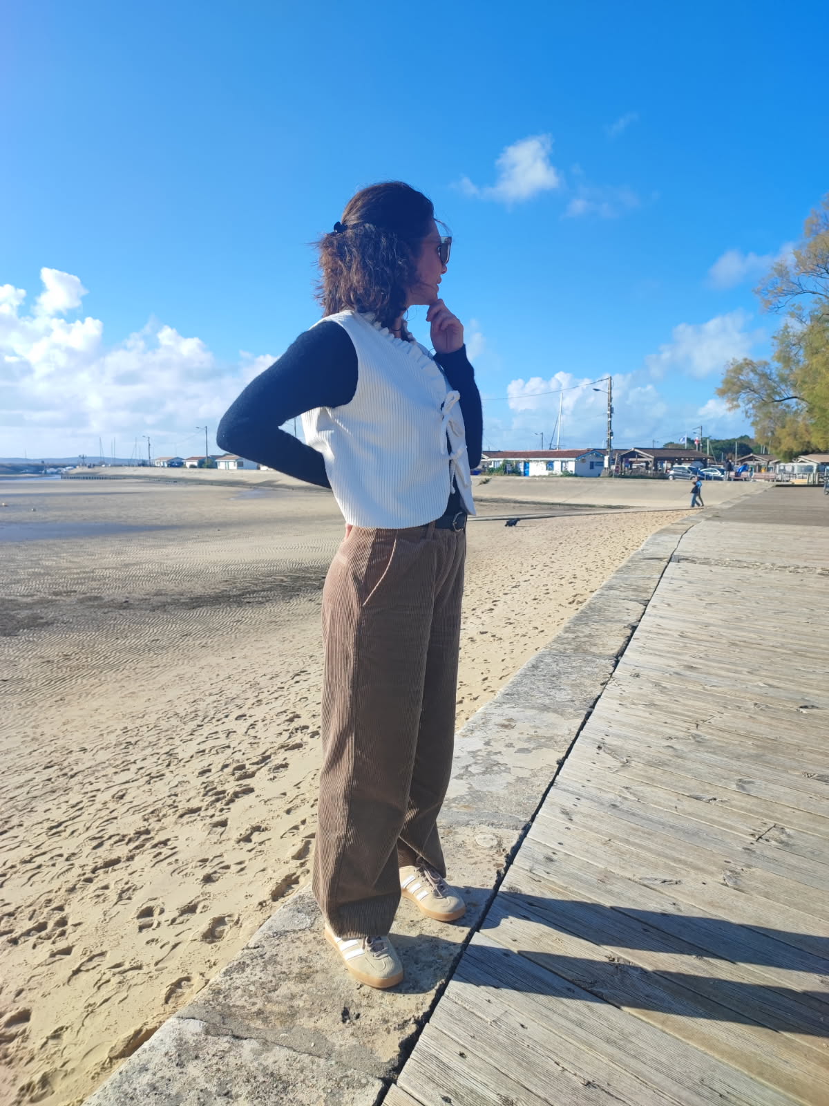 Vue d'une silhouette complète de profil avec le gilet Cosmos en velours côtelé blanc cassé. Gilet confectionné à la main, en France, à la commande.