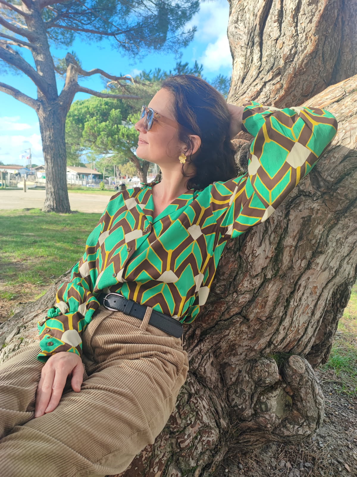 Chemise à manches longues bouffantes au-dessus du poignet, col tailleur. Imprimé style art déco avec des losanges, vert, jaune et beige.